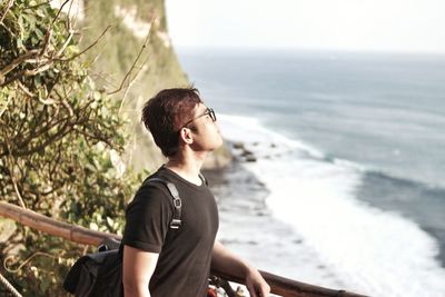 Side view of young man standing on beach