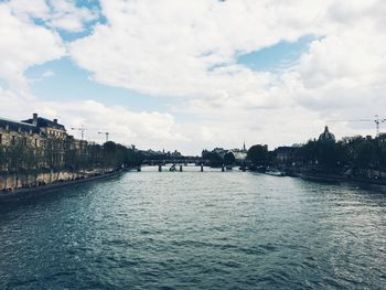 Scenic view of river against sky in city