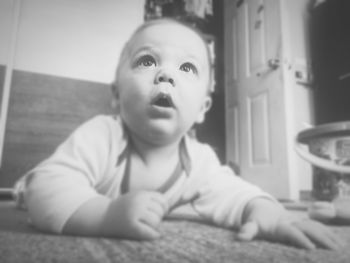 Portrait of cute baby girl sitting on table at home