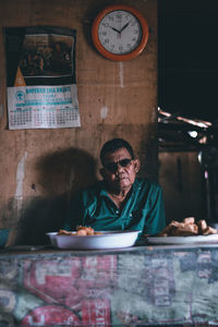 Full length portrait of a young man sitting on table