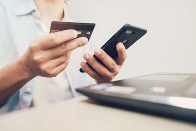 Midsection of man using mobile phone