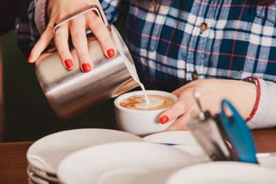 Midsection of barista preparing coffee