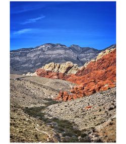 Scenic view of mountains against blue sky