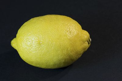 Close-up of yellow fruit against black background