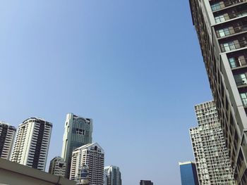 Low angle view of modern buildings against clear blue sky