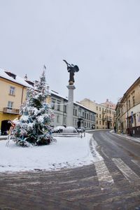 Statue on street against buildings in city