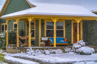 Snow covered house against building