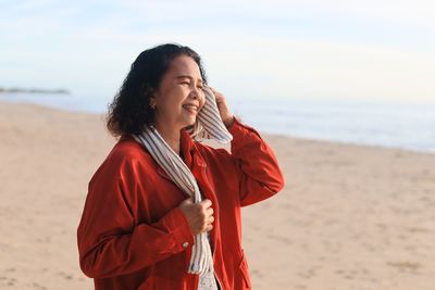 Beautiful young woman standing on beach