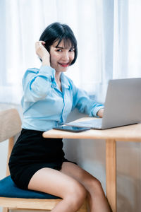 Young woman using laptop at home