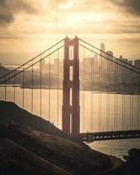 View of suspension bridge against cloudy sky