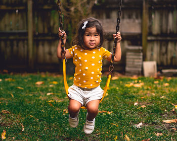 Portrait of cute girl on swing in playground