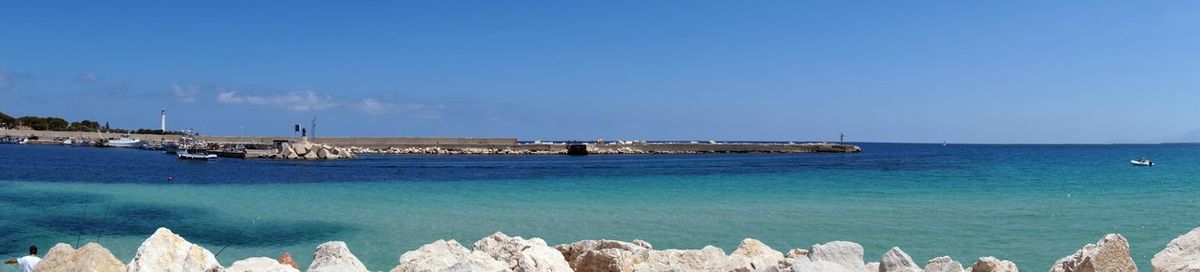 Panoramic view of sea against clear blue sky