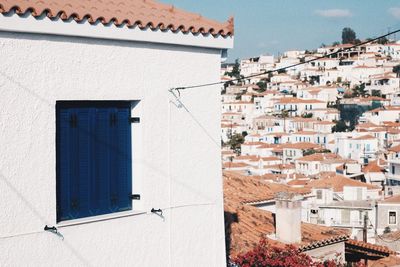 Houses in town against sky during sunny day