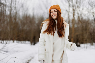 Young woman standing on snow covered field