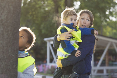 Teacher showing something to boy on playground