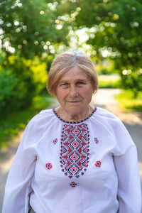 Portrait of woman standing against trees