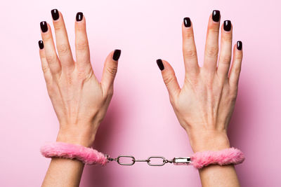 Close-up of woman hand against colored background