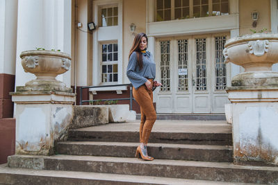 Full length of woman standing against building