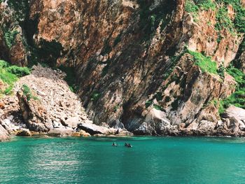 Scenic view of sea against rocky mountain