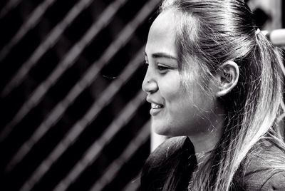 Close-up portrait of smiling young woman looking away