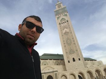 Portrait of man in sunglasses against mosque