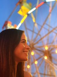 Side view of smiling young woman at amusement park