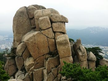 Statue on rock against sky