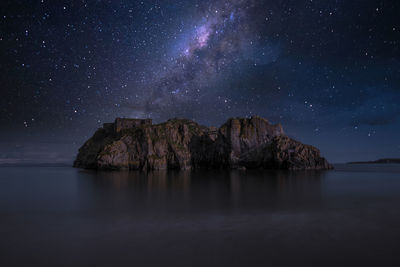 Scenic view of rock formation against sky at night