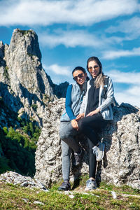 Two young friends hugging during a break while hiking in the mountains