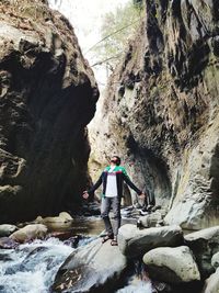 Man standing on rocks at river