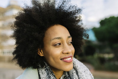Afro woman smiling while looking away outdoors