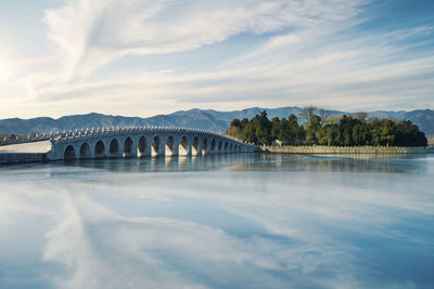 Arch bridge over river against sky