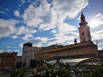 Low angle view of buildings against cloudy sky