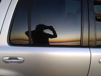 Reflection of man on car window