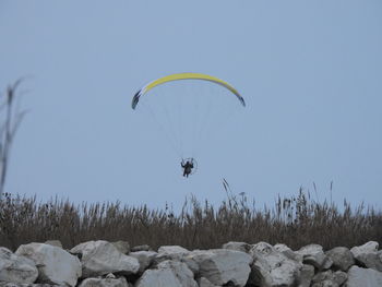 Person paragliding against sky