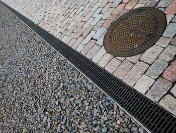 High angle view of manhole on footpath