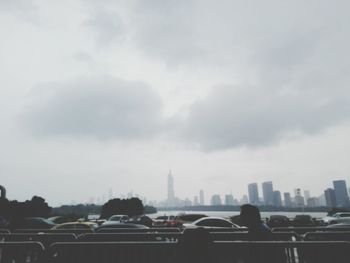 View of cityscape against cloudy sky