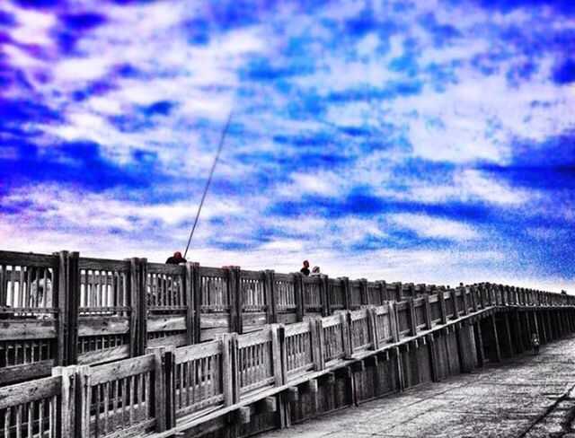 sky, architecture, built structure, cloud - sky, building exterior, railing, cloud, cloudy, connection, bridge - man made structure, the way forward, street light, blue, transportation, low angle view, bridge, diminishing perspective, outdoors, city, cable