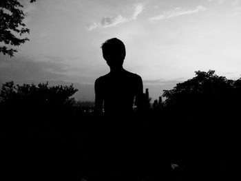 Silhouette man standing against sky during sunset