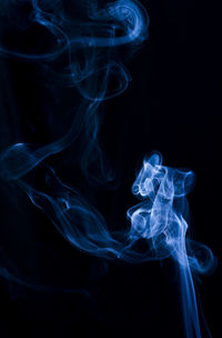 Close-up of blue smoke against black background