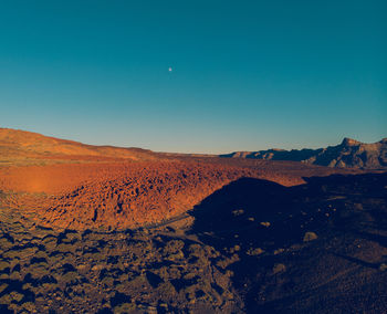 Scenic view of desert against clear blue sky