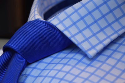 Close-up of blue necktie on checked pattern shirt at store