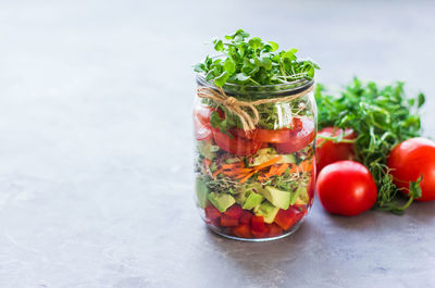 Vegetables salad in open jar tomato, avocado,pepper, cucumber, micro greens healthy food, diet