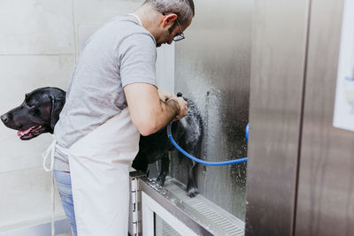 Man cleaning dog with water