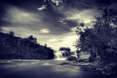 Scenic view of waterfall against sky