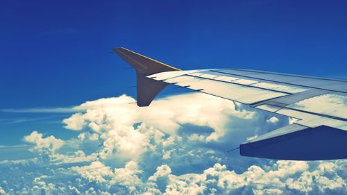 Cropped image of airplane flying over clouds