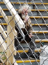 Close-up of man on chainlink fence