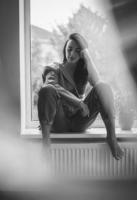 Low angle view of woman sitting on floor at home