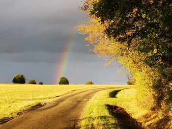 Scenic view of rainbow over landscape against sky