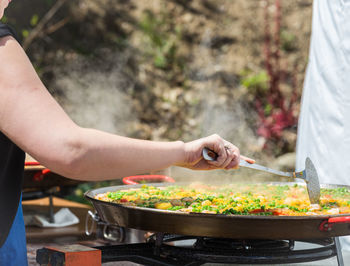 Midsection of woman preparing food at yard